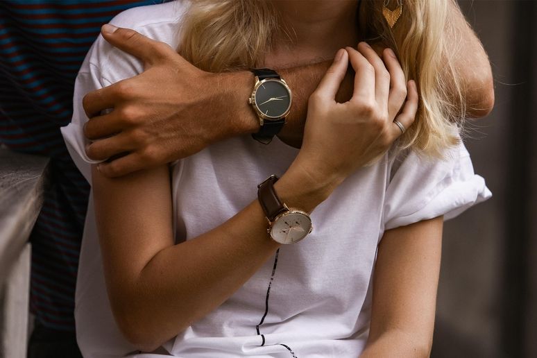 Nahaufnahme von zwei Menschen, die sich umarmen und stilvolle Armbanduhren tragen.